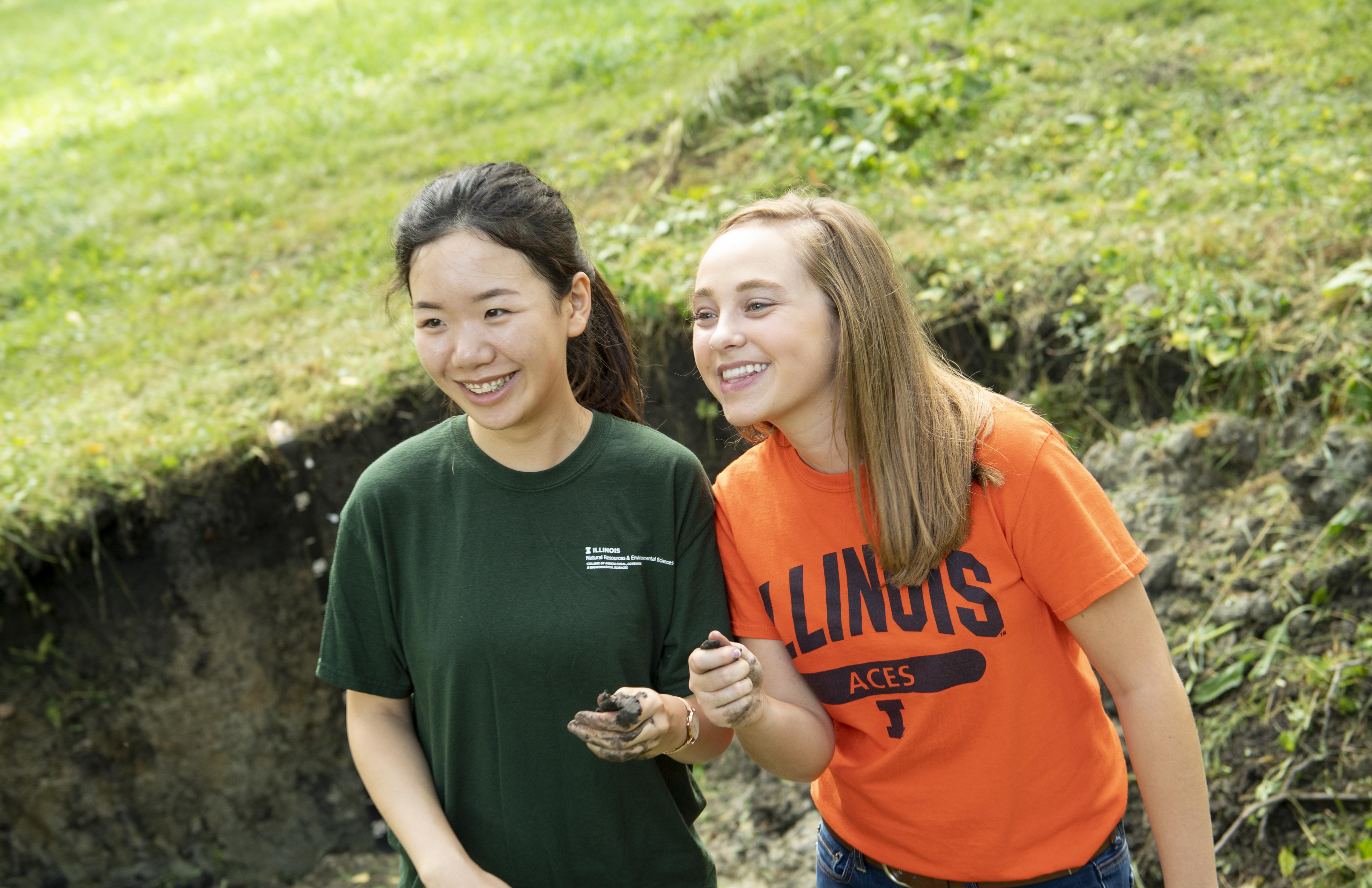 Students holding soil