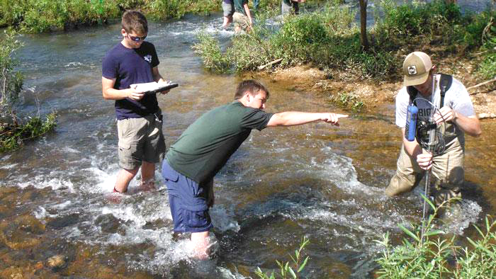 Students working in a creek