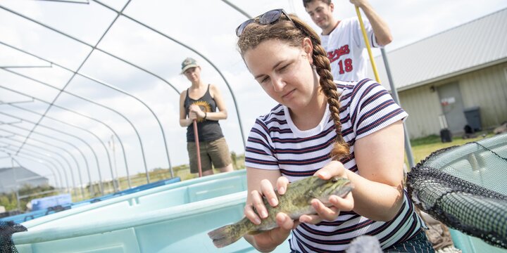 Student holding a fish