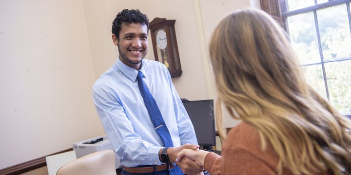 Two people shaking hands in an office