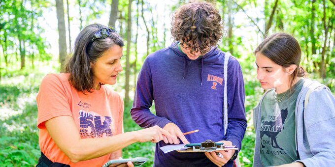 Instructor assisting two students with a project