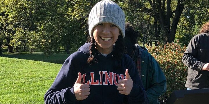Student in Illinois sweatshirt giving thumbs up.