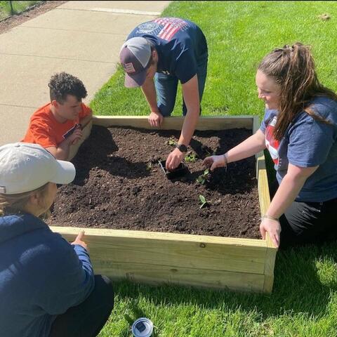 Students in Grow2Give planting a garden bed